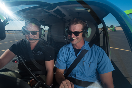 Aviation student and professor learns helicopter controls in hands on learning activity