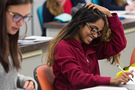Student smiles while working on classwork