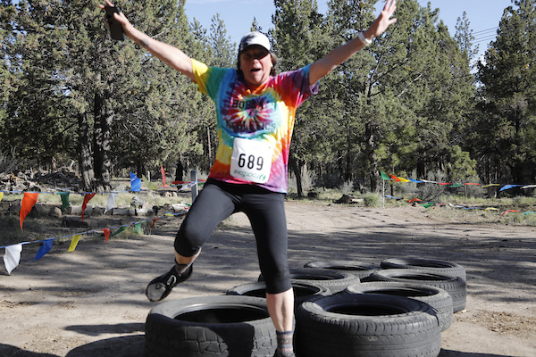 person in tie dye shirt running through tires very excited