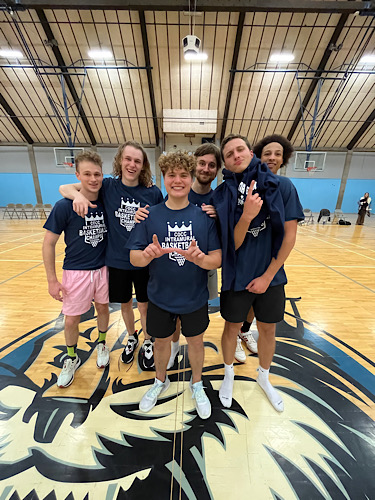 Students posing for picture with intramural basketball shirts on