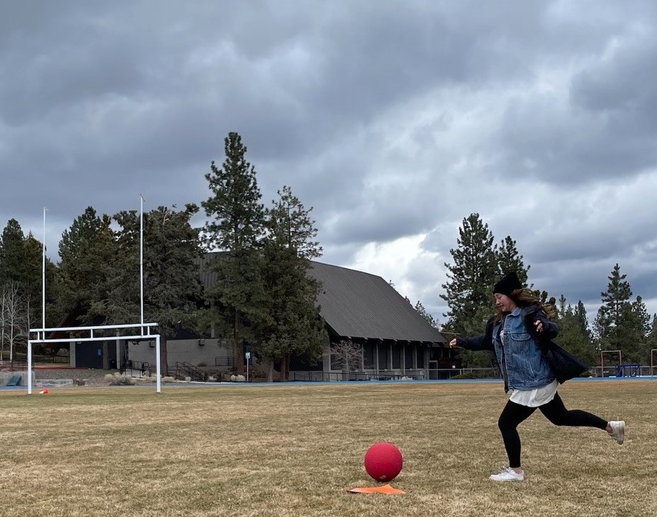 person kicking kickball
