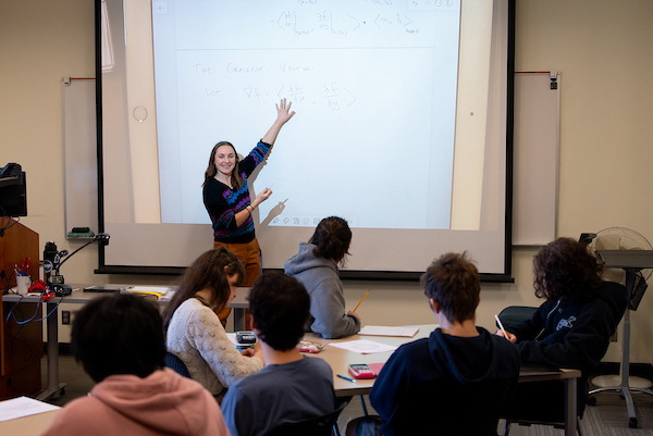 A math instructor engaging with students in a COCC classroom.